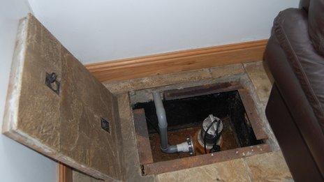 Pit containing submersible pump in the living room