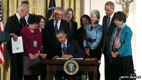 US President Barack Obama signs a memorandum for the Heads of Executive Departments and Agencies regarding establishing a White House Task Force to Protect Students from Sexual Assault during an event for the Council on Women and Girls as Vice President Joe Biden watches in the East Room of the White Hous