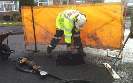 Worker fixing pothole