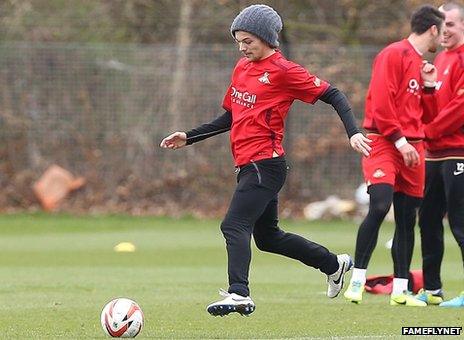 Louis Tomlinson kicking a ball