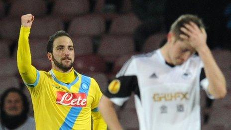 Gonzalo Higuain of Napoli Celebrates scoring leaving Swansea's Ben Davies looking dejected