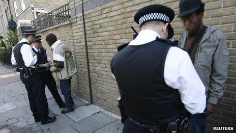 Two men speaking to police officers