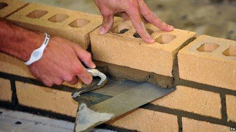 A construction worker laying bricks