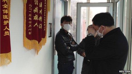 Friends of human right activist Cao Shunli stand in front of an intensive care unit where Cao is hospitalized as they are not allowed to go inside of the unit at a hospital in Beijing (1 March 2014)