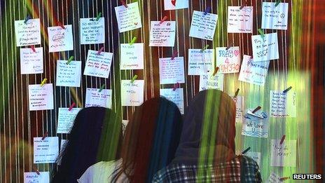 Women look at messages for family members of passengers onboard the missing Malaysia Airlines Flight MH370 at an event to express solidarity in Subang Jaya