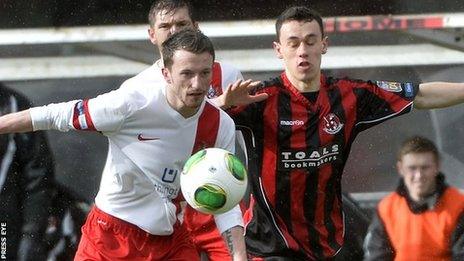 Ards player Willie Faulkner challenges Crusaders winger Paul Heatley