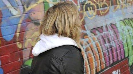 Girl in front of wall covered in graffiti