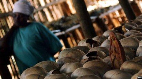 A survivor of a massacre in Rwanda stands in crypt where skulls of some of the 5,000 victims of that killings are exposed