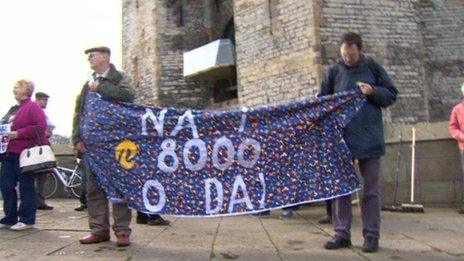 Protesters hold a sign