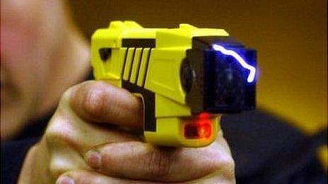 Taser being held by police officer