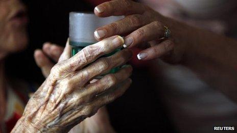 Nurse gives elderly woman a drink