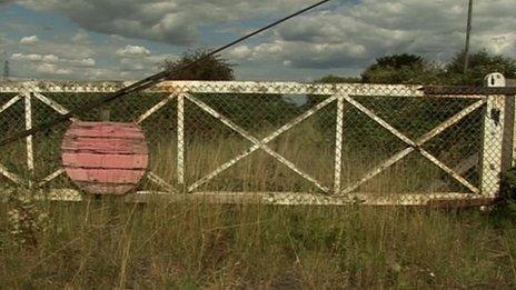 Disused gate at overgrown rail crossing