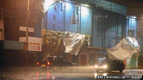 Traffic makes its way past a damaged building at Blackpool Promenade