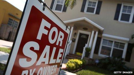 A "FOR SALE" sign in front of a house