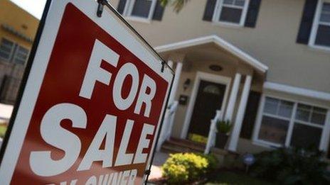 A "FOR SALE" sign in front of a house