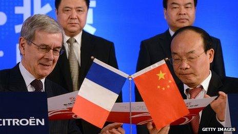 Philippe Varin (L) chairman of PSA Peugeot Citroen, and Xu Ping (R), executive chairman of Dongfeng Motor Group, sign a strategic partnership agreement in Beijing on March 28, 2014