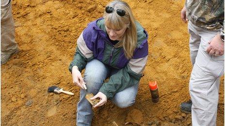 Erin Kimmerle examines an object in the field