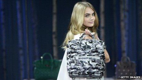 Model Cara Delevingne poses with a Mulberry handbag