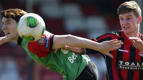 Glentoran's William Garrett in action against David McAllister of Crusaders