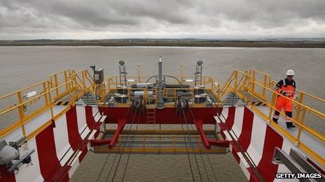 A worker walks around the end of one of the quay cranes at DP World London Gateway Port