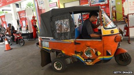 A bajaj fills up at a state-owned petrol station in Jakarta