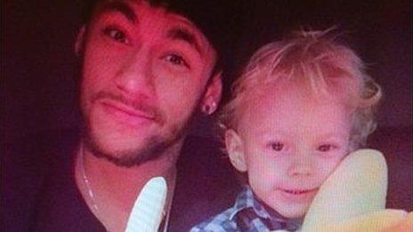 Neymar, side by side with his son, holding a banana