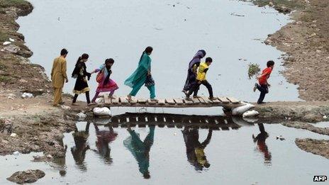 Pakistani residents cross the Ravi river in Lahore