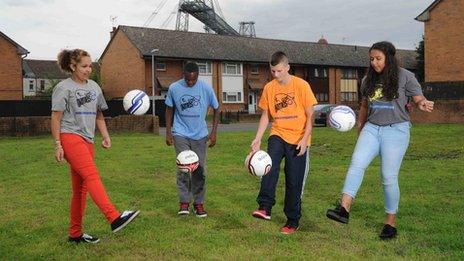 Youngsters play football in a local green area