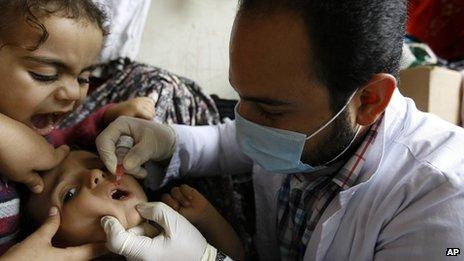 A Syrian child receives a polio vaccination