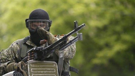 A pro-Russian gunman on top of a car patrols through the centre of Sloviansk