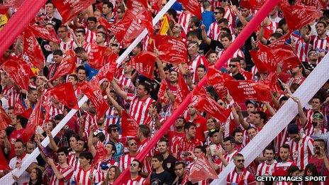 Atletico de Madrid fans wave red plastic flags supporting their team prior to start the La Liga match