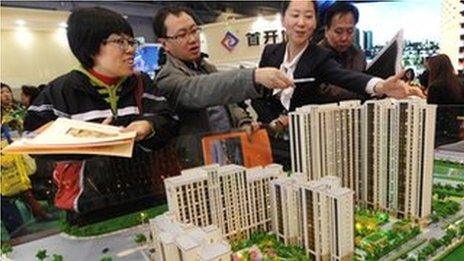 Buyers looking at a model of a new home development in China