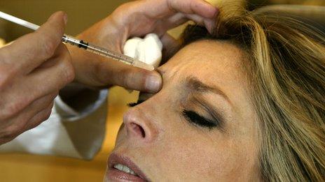 Injecting Botox into woman's face