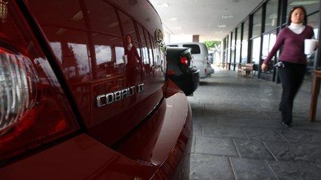 Chevrolet Cobalt and woman walking by