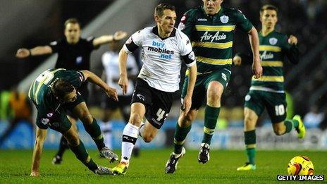 Craig Bryson of Derby County runs past Clint Hill and Richard Dunne of Queens Park Rangers