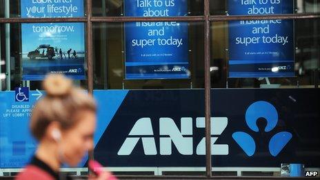 Woman walks past ANZ signage