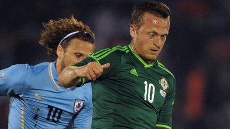 Diego Forlan of Uruguay in action against Northern Ireland's Sammy Clingan