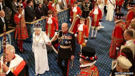 The four pageboys hold the train of the Queen's gown as she arrives at the House of Lords