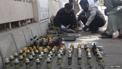 Members of the Bomb Disposal Squad (BDS) defuse explosives and hand grenades along a sidewalk outside Jinnah International Airport in Karachi June 9, 2014.