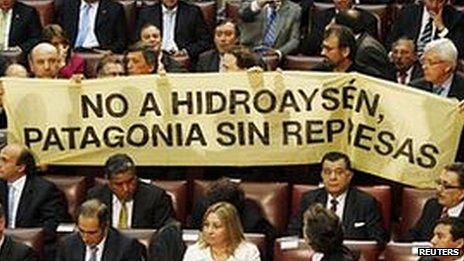 Opposition deputies hold up a placard in protest against the dam during President Sebastian Pinera's annual address at the national congress building in Valparaiso city on 21 May, 2011