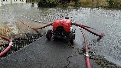 Flooding water being removed from a property along Bulwer Avenue after storms in February