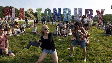 Festival-goers play a game, batting a beer can with a Wellington boot, on the first day of the Glastonbury music festival at Worthy Farm in Somerset, in this June 27, 2013