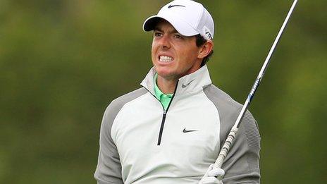 An anxious McIlroy watches his approach at the 14th hole, which he bogeyed