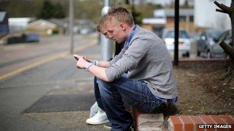 Two young men looking at their mobile phones