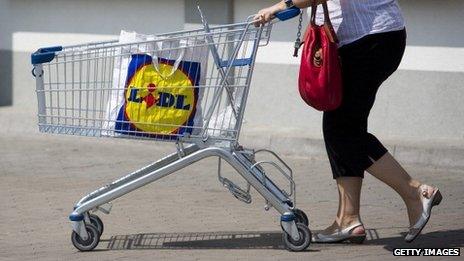 A woman with a shopping trolley and Lidl shopping bag