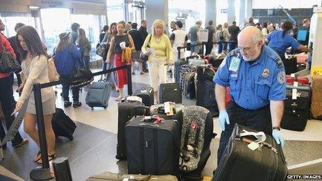 A TSA agent checks luggage as passengers arrive for flights at O'Hare International Airport in Chicago, Illinois 23 May 2014