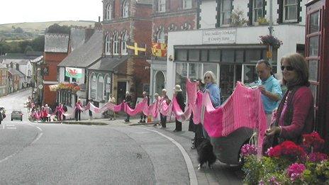 People line the street carrying the scarp