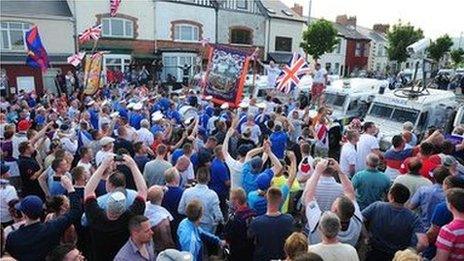 Crowd blocked by police vehicles