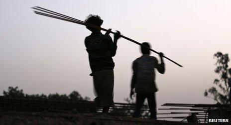 Workers carrying rebar