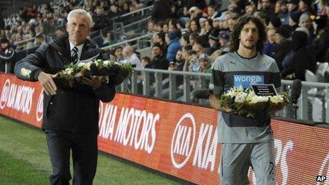 Alan Pardew and captain Fabricio Coloccini carrying wreaths in memory of the two victims